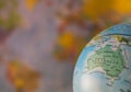 Australiamap on a globe with earth map in the background. Royalty Free Stock Photo