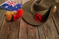 Australian Anzac Day. Australian army slouch hat red poppy and traditional Anzac biscuits on wooden background. Royalty Free Stock Photo