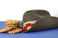 Australian army slouch hat and traditional Anzac biscuits on white and blue background Royalty Free Stock Photo