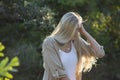 Australian Beauty with Long Blond Hair Looks Down with Sun Streaming Through Hair