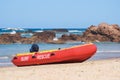 Australian coast, red lifeguard pontoon on the shore, guarded city beach with sand and rock shore on a sunny summer day