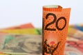 An rolled Australian twenty dollar note with a background of notes. Royalty Free Stock Photo