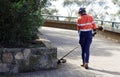 Australian female landscaper worker trimming edges in local park