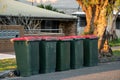 Australian garbage wheelie bins with colourful lids for general household waste on the street kerbside for council rubbish