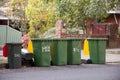 Australian garbage wheelie bins with colourful lids for recycling and general household waste lined up on the street kerbside