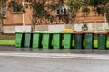 Australian garbage wheelie bins with yellow and red lids for recycling and household waste lined up on the street near residential