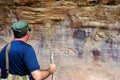 Australian man look at Indigenous Australian rock art painting Cape York peninsula Queensland Australia