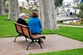 Australian old men and senior women travel and sit relax on bench in garden at Pe