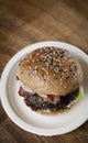 Organic beef burger with bacon on wood table