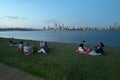 Australian people having a weekend picnic on Swan river against Perth central business district skyline