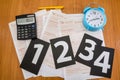 Australian tax forms with pen, blue alarm clock and calculator on the table. View from above. Tax concept. The numbers on the stic