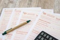 Australian tax forms with pen and calculator on a wooden table