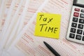 Australian tax forms on a table with a calculator and pen. Tax concept. `tax time` on the sticker.