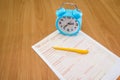 Australian tax forms with a yellow pen and a blue alarm clock on the table. Tax concept.