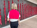 Australian woman looking at red poppies at Australian War Memorial Royalty Free Stock Photo