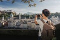 Austria. Salzburg. Young girl tourist taking pictures on mobile