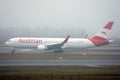 Austrian Airlines plane doing taxi on taxiway, fog