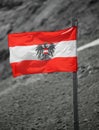 Austrian flag with the symbol of the crowned eagle and the colors white and red waving in the wind Royalty Free Stock Photo