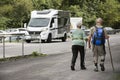 Austrian people senior couple walking beside road go to trekking and hiking at mountain