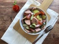 Austrian sausage salad `Wurstsalat` is a traditional snack and a light summer dish