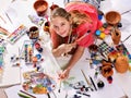 Authentic artist children girl paints on floor. Top view.