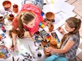 Authentic artist children girl paints on floor. Top view.