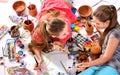 Authentic artist children girl paints on floor. Top view.