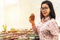 Authentic Asian woman smiling holding cactus in a plastic plant pot in the cactus shop. Concept of the indoor garden home Royalty Free Stock Photo