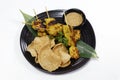 Authentic Asiatic street food chicken satay with peanut sauce and shrimps crackers on bamboo leaves Royalty Free Stock Photo