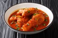 Authentic Ayam Masak Merah Recipe made with chicken pieces that are doused in a spicy tomato sauce close-up in a bowl. Horizontal