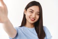 Authentic body-positive shot asian cute tender happy girl extend hand hold camera taking selfie smartphone smiling