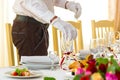 Preparing for a banquet. Waiter places glasses on a banquet table. The feast begins Royalty Free Stock Photo