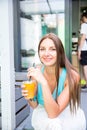 Authentic close up shot of an young brunette long hair woman drinking healthy dietetic biological natural orange juice