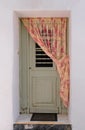 Authentic doorway of traditional Greek house, white walls, curtain. Royalty Free Stock Photo