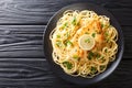 Authentic fried breaded chicken Francaise with spaghetti in lemon wine gravy close-up on a plate. Horizontal top view