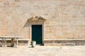 Authentic house with a stone wall and a beautiful green door and with a beautiful stone bench at the entrance