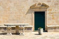 Authentic house with a stone wall and a beautiful green door and with a beautiful stone bench at the entrance