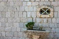 Authentic house with a stone wall and a beautiful green door and with a beautiful stone bench at the entrance