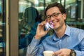 Authentic image of a businessman working in a cafe. Man talking on the mobile phone in a coffee shop Royalty Free Stock Photo