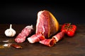 Authentic Italian Prosciutto Dry-Cured on wooden background. Air-Dried Ham and organic tomates. Close-up Royalty Free Stock Photo