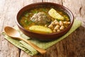 Authentic kufta bozbash meat soup with lamb meatballs, chickpeas, vegetables and herbs close-up in a plate. horizontal