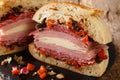 Authentic New Orleans Muffuletta sandwich filled with olive salad, cheese, salami and ham close-up on a slate board. Horizontal Royalty Free Stock Photo