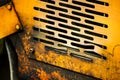 Authentic old style industrial background. Close-up of a dirty part of an old road roller. Orange colored metal Royalty Free Stock Photo