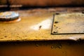 Authentic old style industrial background. Close-up of a dirty part of an old road roller. Orange colored metal Royalty Free Stock Photo