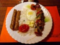 Authentic Persian cuisine Chelow Kebab. Mutton seekh kebab and Chicken kebab served with raw egg, grilled onion and tomato, and Royalty Free Stock Photo