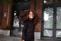 Authentic portrait African American child girl smiling and looking camera, walking city street. Beautiful fashion model
