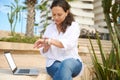 Authentic portrait of confident multi ethnic young business woman checking time on wrist watch, online working on laptop Royalty Free Stock Photo