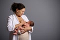 Authentic woman, happy young mother, holding her newborn baby suckling at her breast, feeding him with mother milk Royalty Free Stock Photo