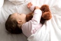 Authentic portrait cute caucasian little infant chubby baby girl or boy in pink sleep with teddy bear on white bed