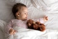 Authentic portrait cute caucasian little infant chubby baby girl or boy in pink sleepy upon waking with teddy bear Royalty Free Stock Photo